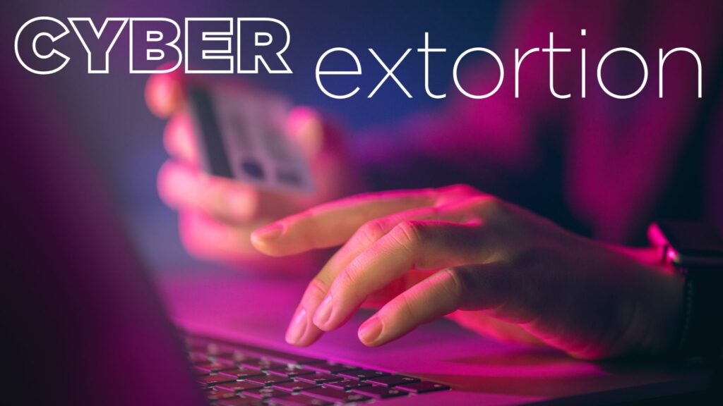 Close-up of a person holding a smartphone and typing on a laptop keyboard with the text "CYBER extortion" in the background, as the screen emits an urgent BEEP.